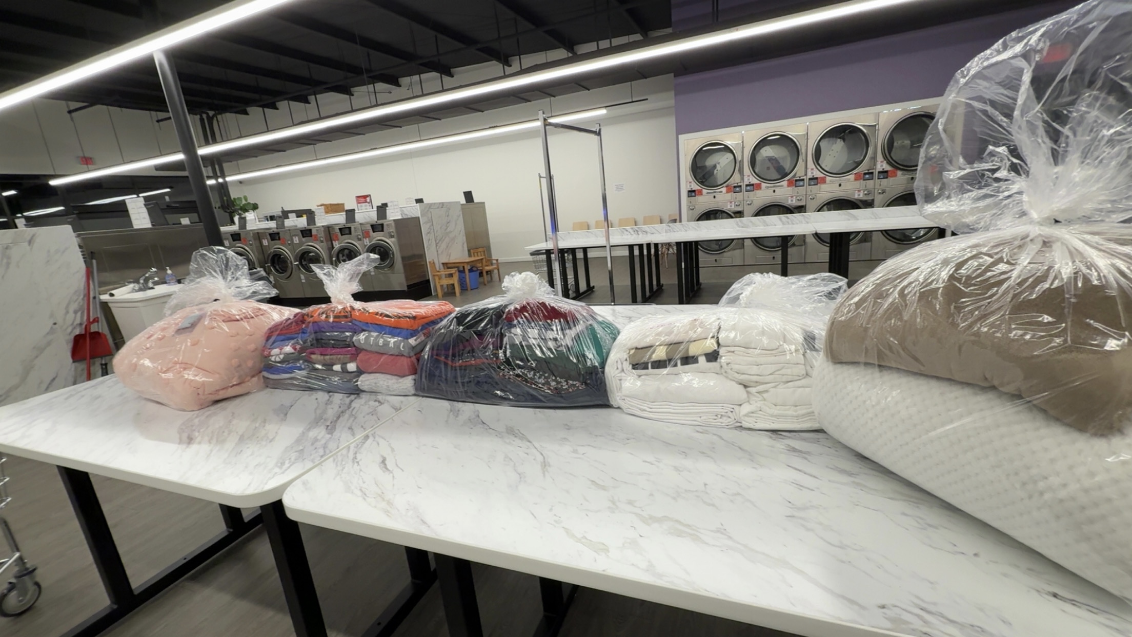 Freshly folded, bagged laundry ready for pickup at Top Tier Coin Laundry